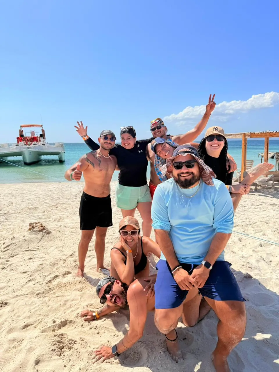 Grupo de viajeros y equipo en una playa del Caribe